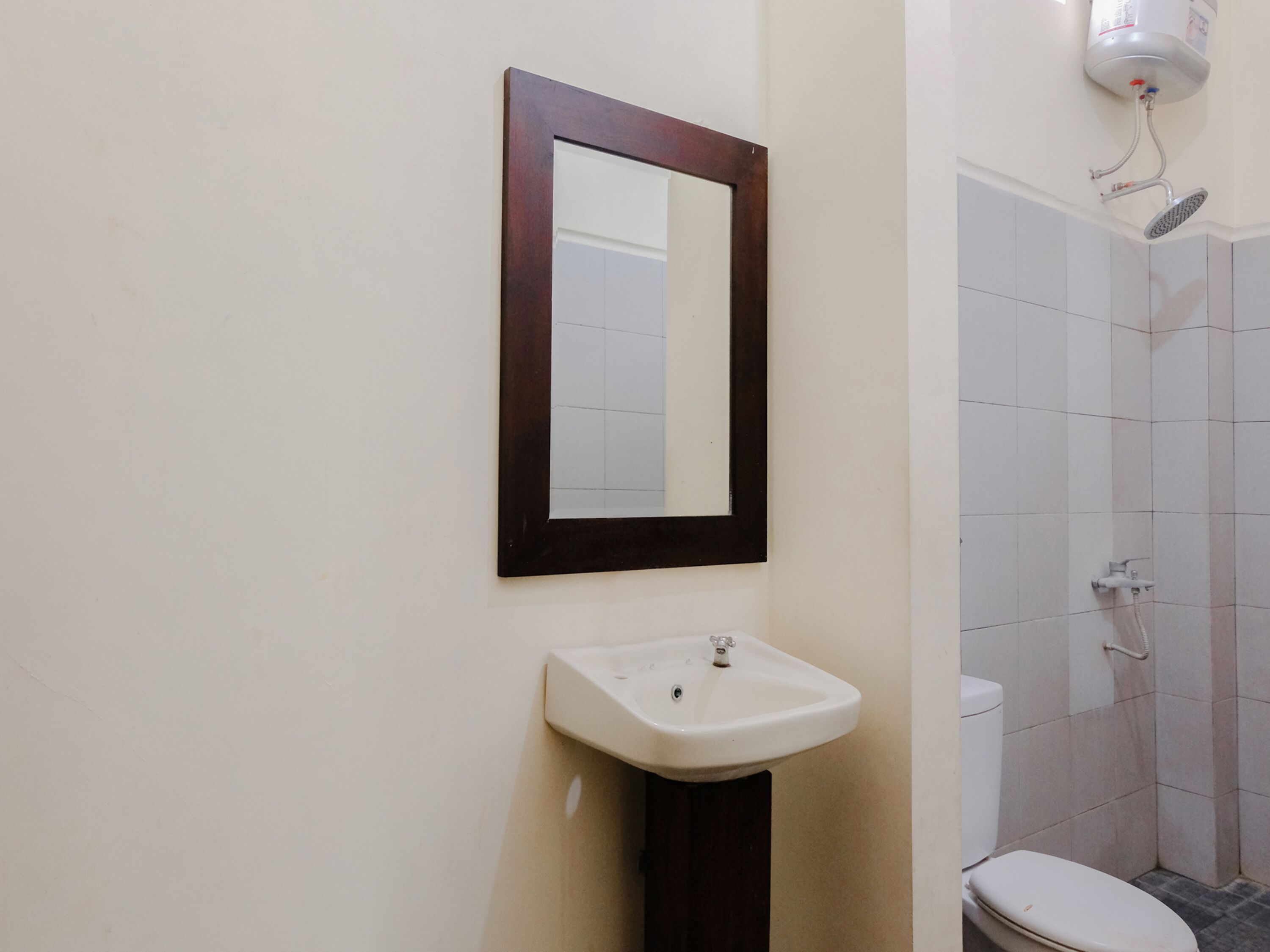 A bathroom with a white sink, a mirror, and a shower.