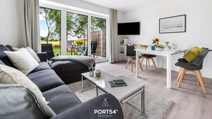 Ett modernt vardagsrum med en soffa, ett soffbord och en matplats.
