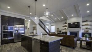 A modern kitchen with a central island, stainless steel appliances, and pendant lighting. - Arcadia 54 | Private Hot Tub * Ping Pong * Nintendo (Santa Clara)