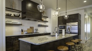 A modern kitchen with dark wood cabinets, stainless steel appliances, and a granite countertop. - Arcadia 54 | Private Hot Tub * Ping Pong * Nintendo (Santa Clara)