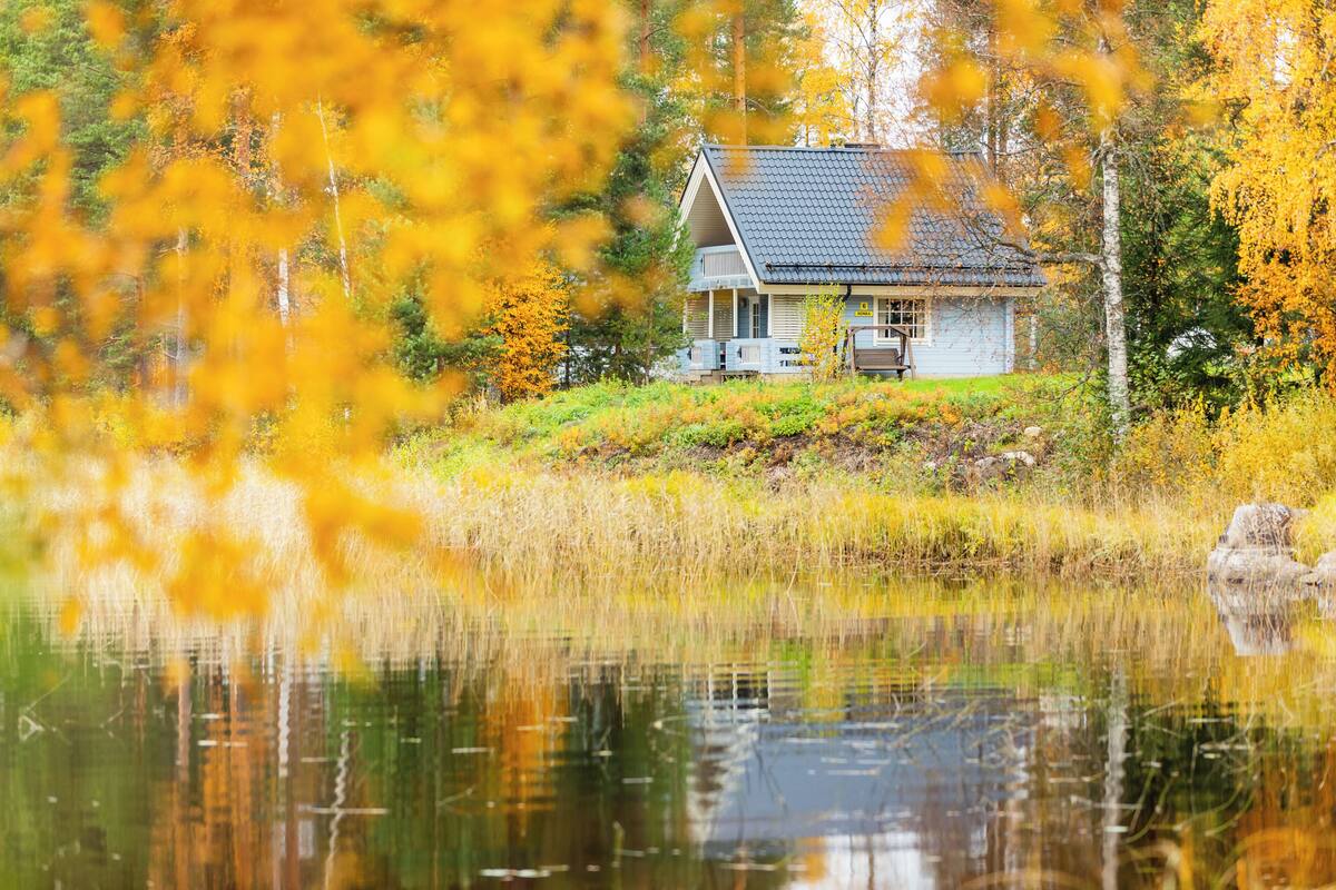 A house by a lake with a reflection in the water.