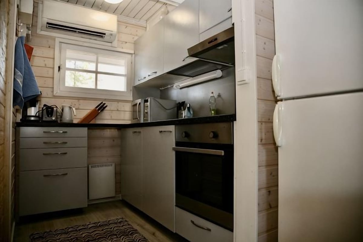 A compact kitchen with a microwave, oven, and stainless steel appliances.