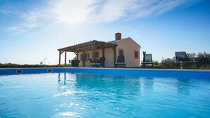 A swimming pool with a covered area, lounge chairs, and a building in the background. - Secluded Pool Villa Sofija Near Zadar (Škabrnja)