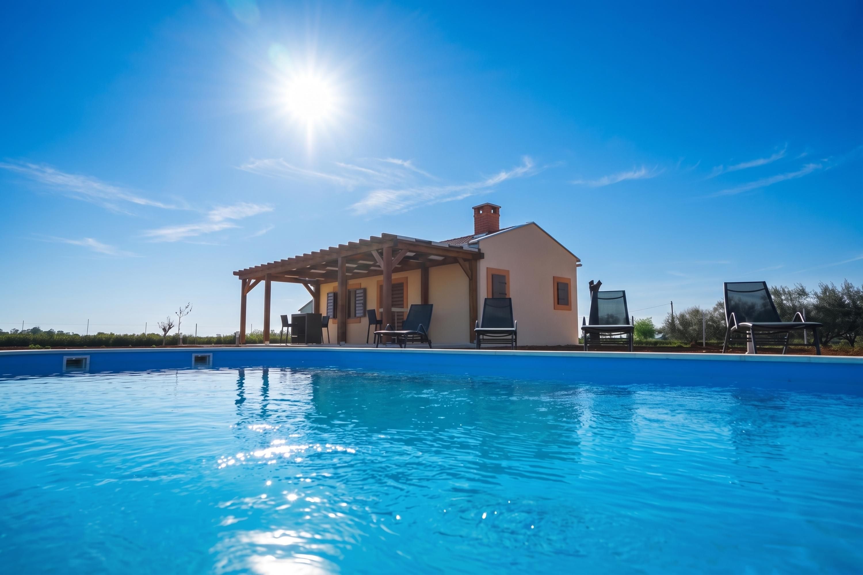 A pool with lounge chairs and a pergola structure.