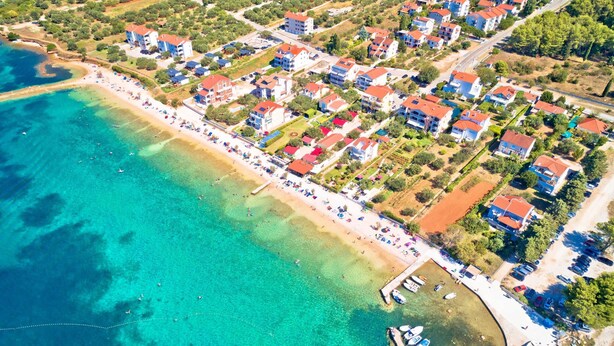 An aerial view of a coastal town with a beach, residential buildings, and a marina. - Secluded Pool Villa Sofija Near Zadar (Škabrnja)
