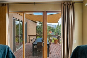 Enjoy a serene view of the surrounding trees and mountains from the deck, complete with a table and chairs.