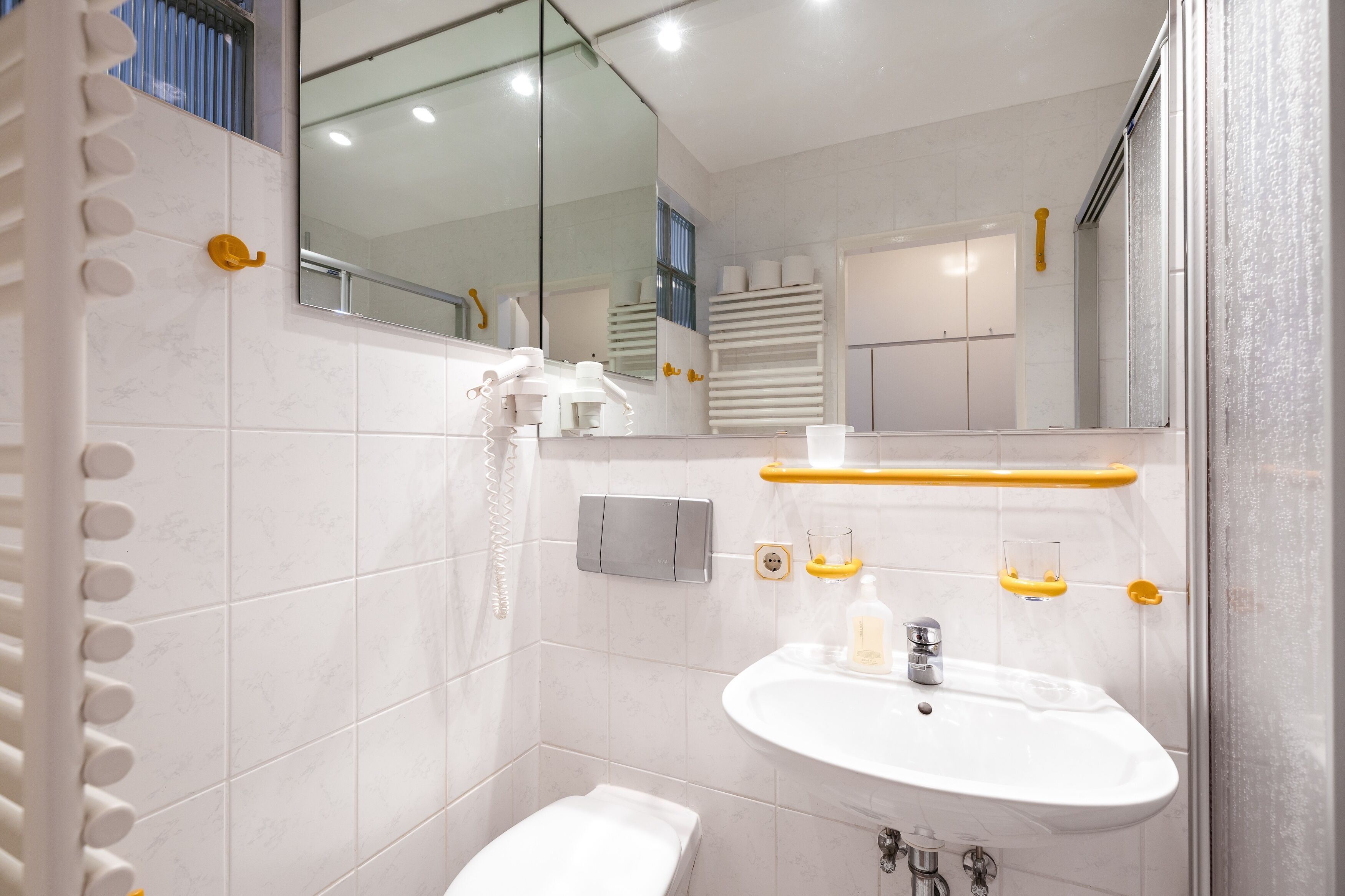 Ein modernes Badezimmer mit Waschbecken, Spiegel und Toilette.