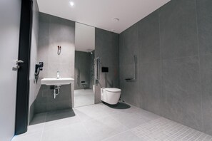 Une salle de bain moderne avec un lavabo, des toilettes et une douche.