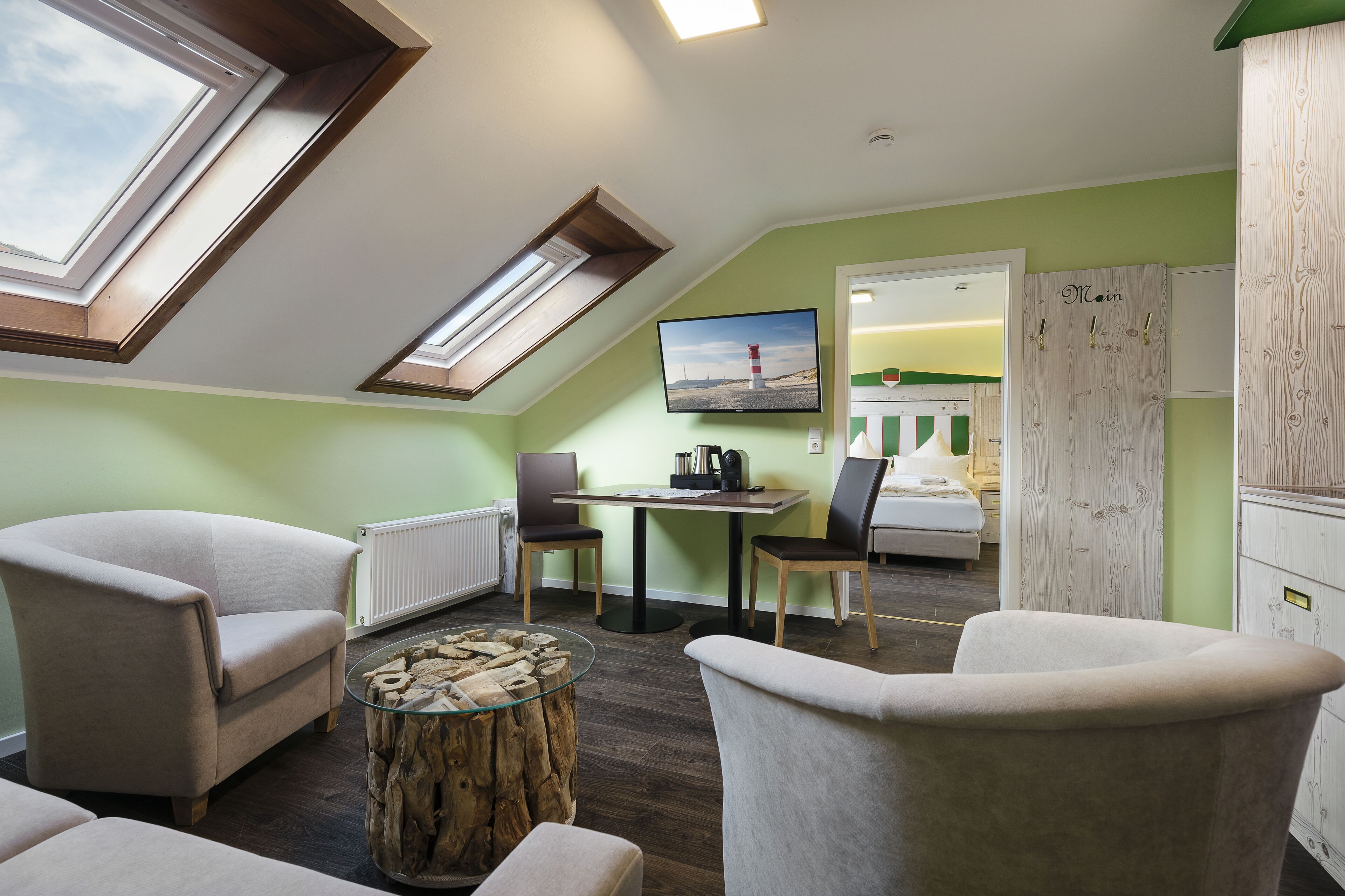 A cozy room with a loft bed, a dining table, and a TV.