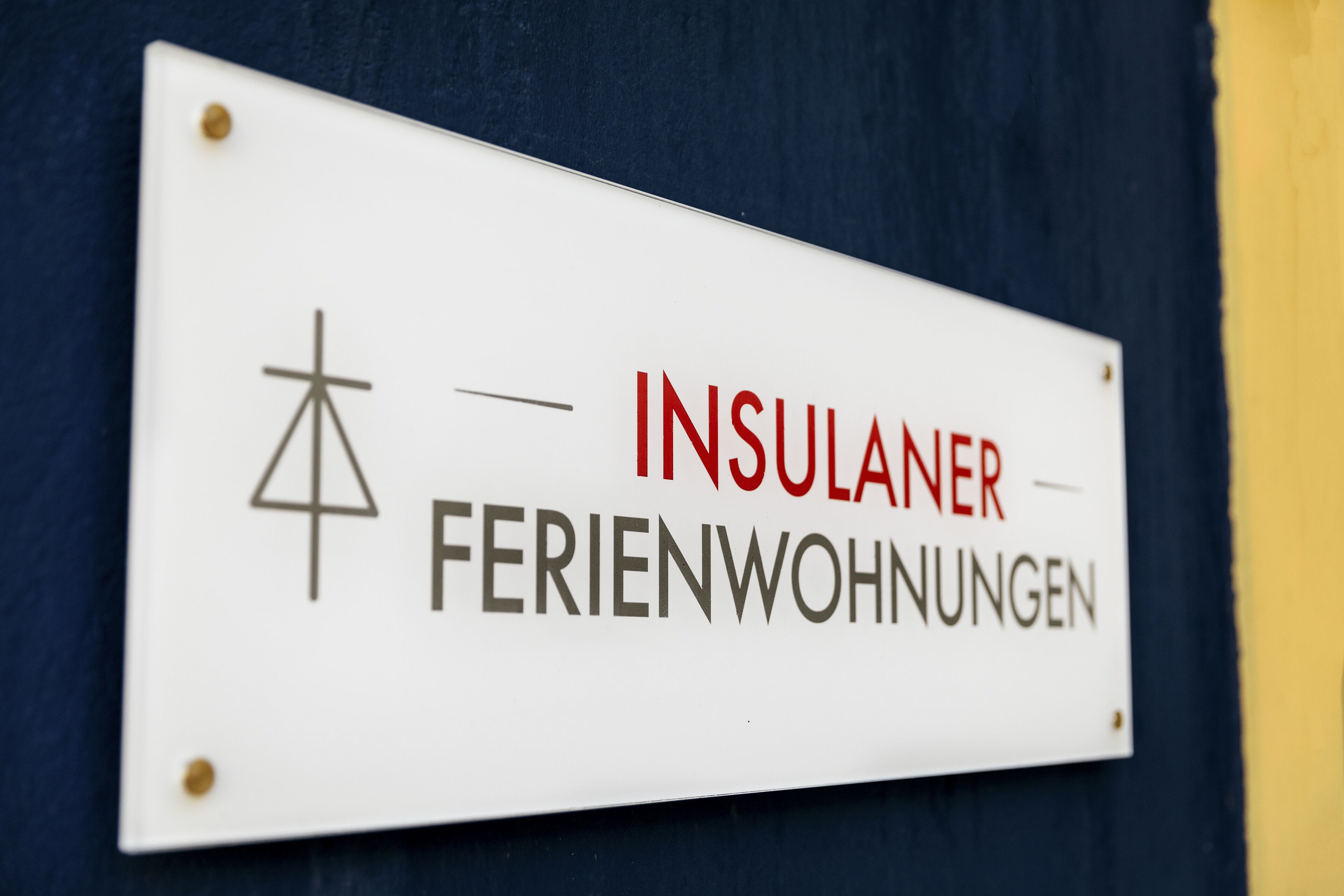 A sign with the text "INSULANER FERIENWOHNUNGEN" and a symbol.