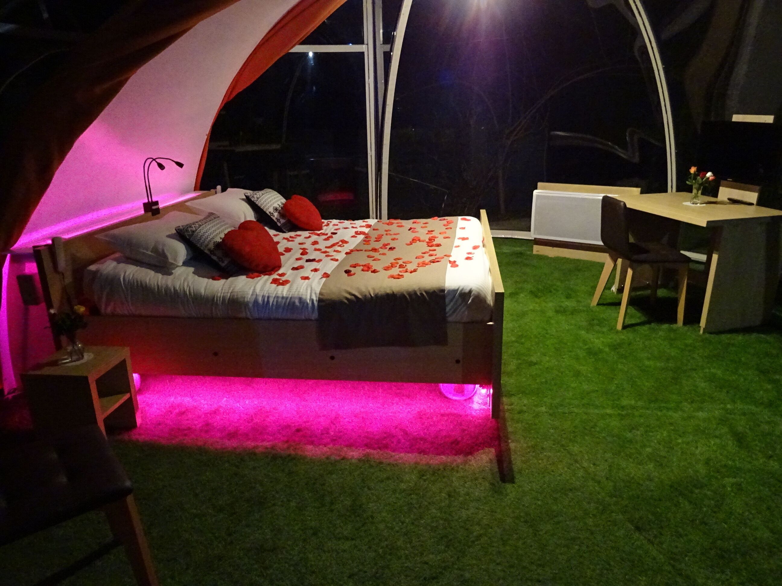 Ein Zelttyp-Zimmer mit Bett, Schreibtisch und Stuhl.