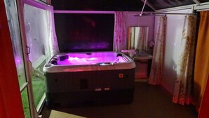 A hot tub in a room with a glass door leading outside. - La Bulle sous les pins (PMR option) (Roquebrune-sur-Argens)