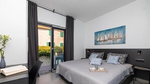 Un dormitorio moderno con una cama grande, un escritorio y una ventana con cortinas.