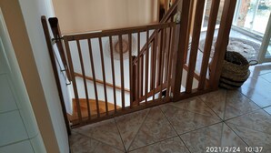 Une porte en bois donnant sur un escalier dont les marches sont recouvertes de carreaux décoratifs.