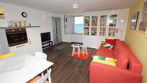 A compact living space with a kitchenette, a dining area, a sofa, and a bookshelf. - Apartment El Corsaro 2 (Rovinj)