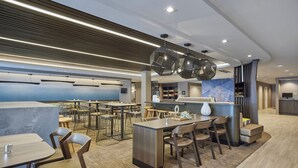 Un restaurant modern amb zona de bar, diverses opcions de seients i un disseny contemporani.