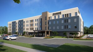 Un hôtel moderne doté d’un toit plat, de plusieurs étages et d’un parking.