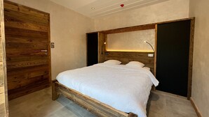 Ein Schlafzimmer mit einem hölzernen Bettgestell, einem großen Spiegel und einem Nachttisch.