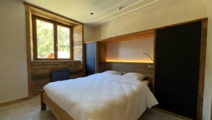 Un dormitorio con una cama grande, una ventana, un escritorio y un armario.
