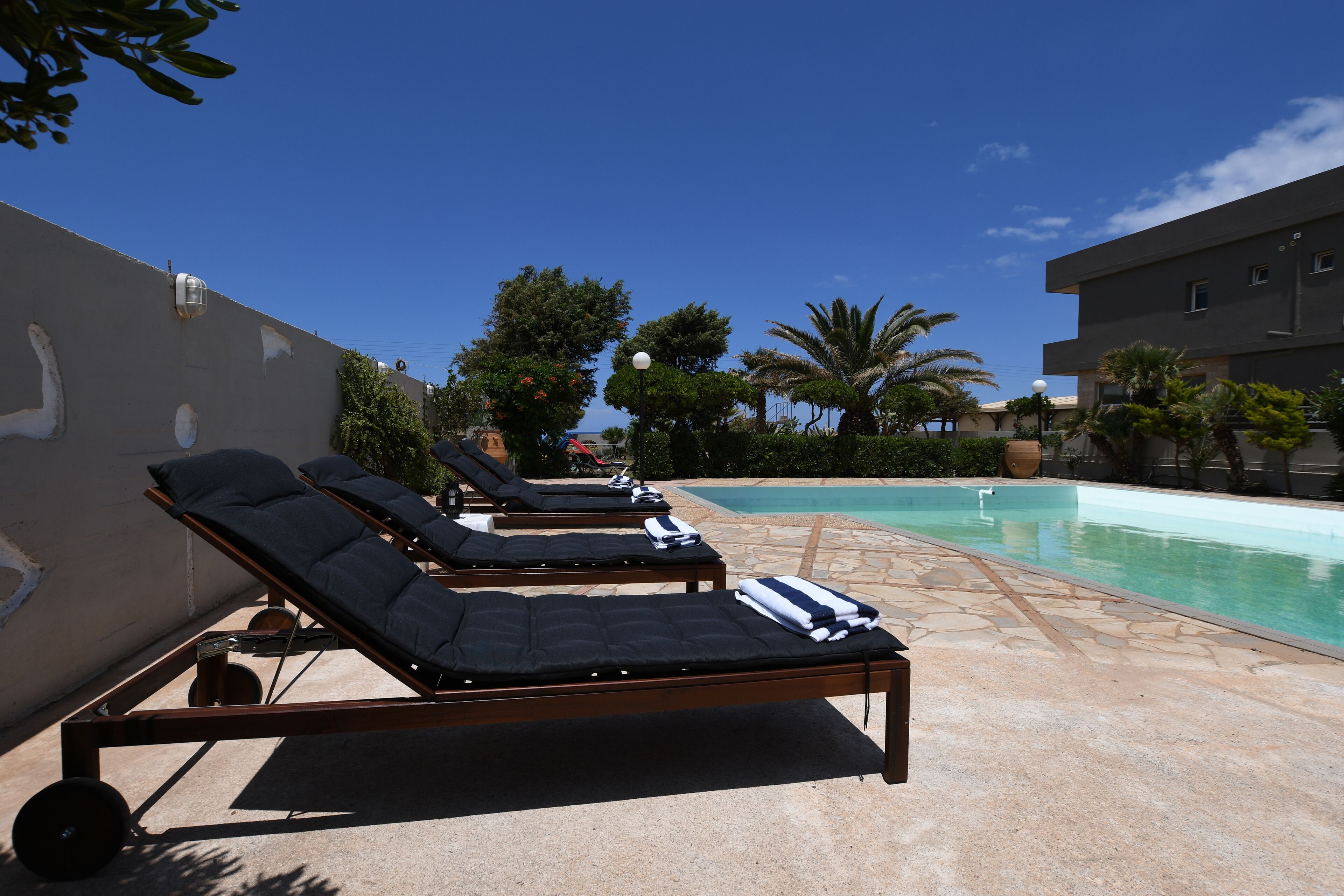 Un espace aménagé au bord de la piscine, avec des chaises longues et une piscine.