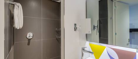 A modern bathroom with a shower, a sink, and a mirror.