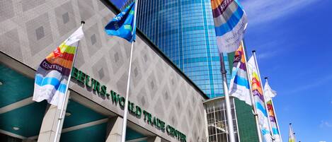 The exterior of the BEURS-WORLD TRADE CENTER with multiple flags and a modern glass building.