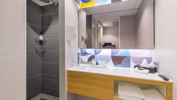 A modern bathroom with a shower, a sink with a mirror, and a towel rack.