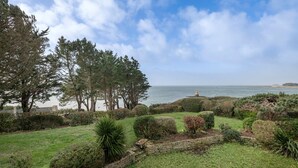 A coastal garden with a stone wall, various shrubs, and tall trees. - Arzon- house for 2 with great seaview (Arzon)