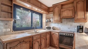 A kitchen with wooden cabinets, a stainless steel sink, a microwave, and an oven. - Arzon- house for 2 with great seaview (Arzon)