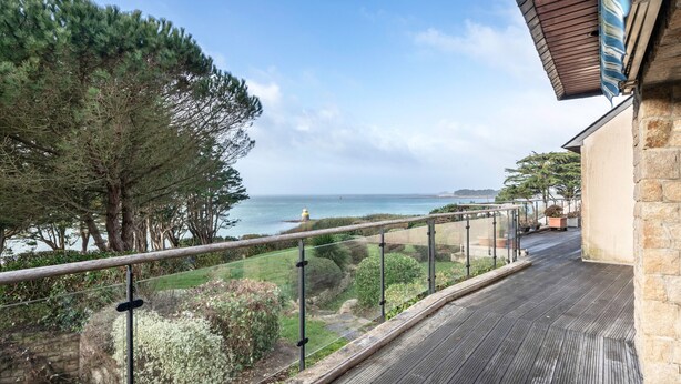 A balcony with a view of the sea, a stone wall, and a wooden deck. - Arzon- house for 2 with great seaview (Arzon)