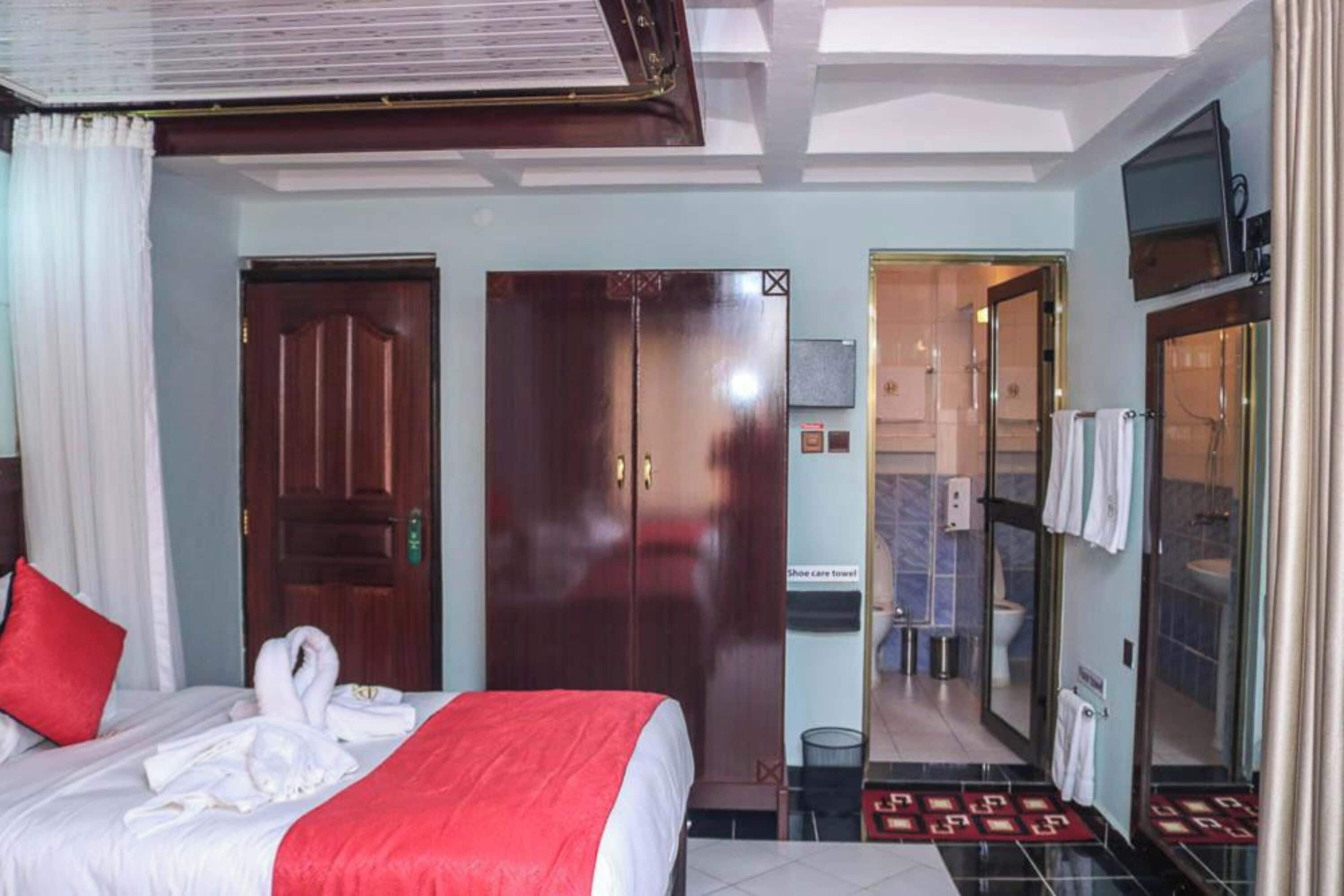 Ein Hotelzimmer mit Bett, Schrank, Badezimmer und Fernseher.