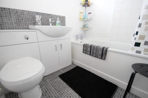 A bathroom with a white toilet, a sink, a bathtub, and a shower area. - Cosy 2-bed House in Kinlochbervie (Kinlochbervie)