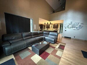 Uma sala de estar moderna com sofá de canto, mesa de centro e tapete colorido.
