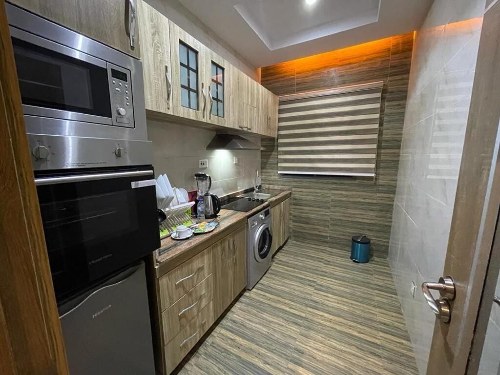 A compact kitchen with a built-in oven, microwave, and washing machine.