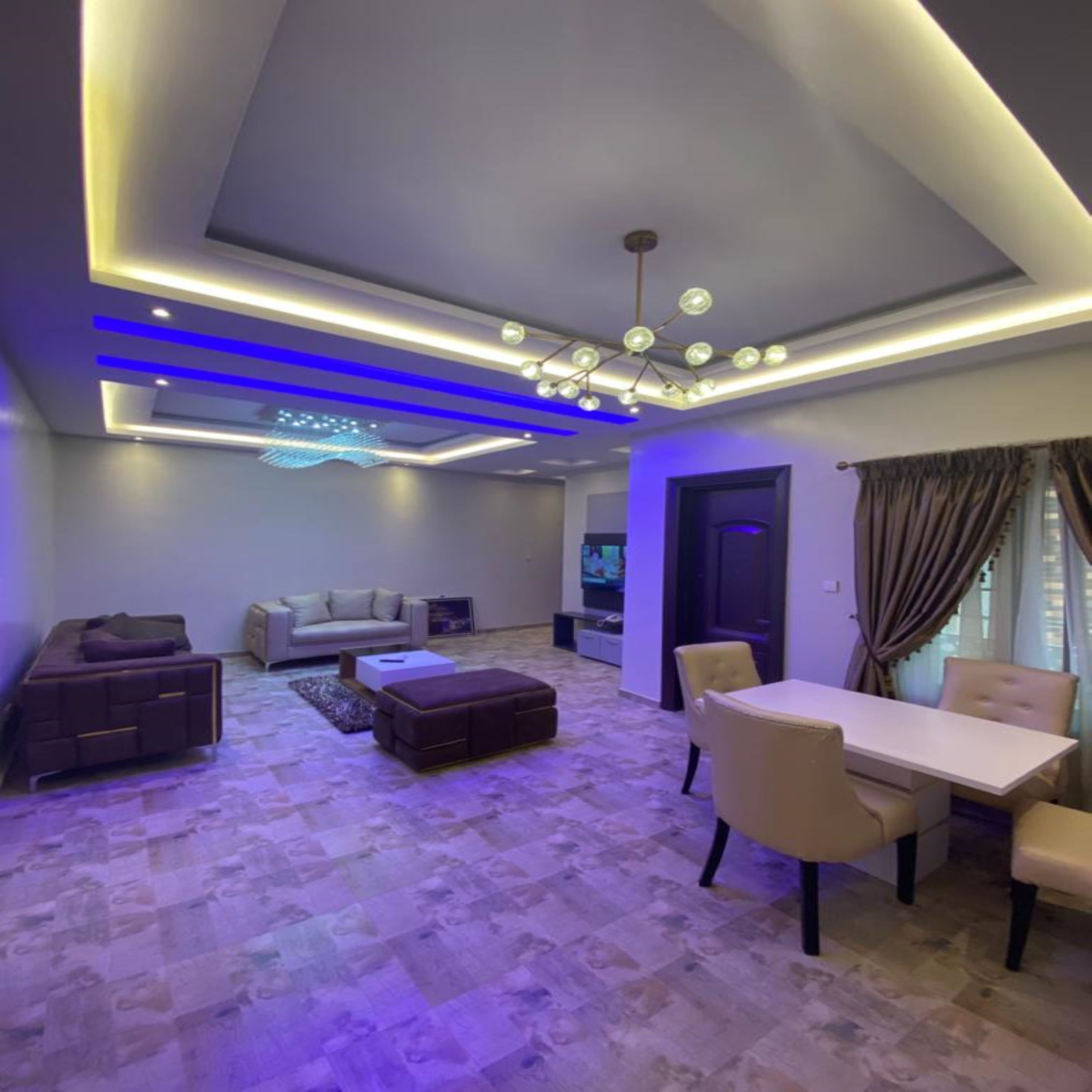 A modern living room with a sofa, a coffee table, and a dining table with chairs.