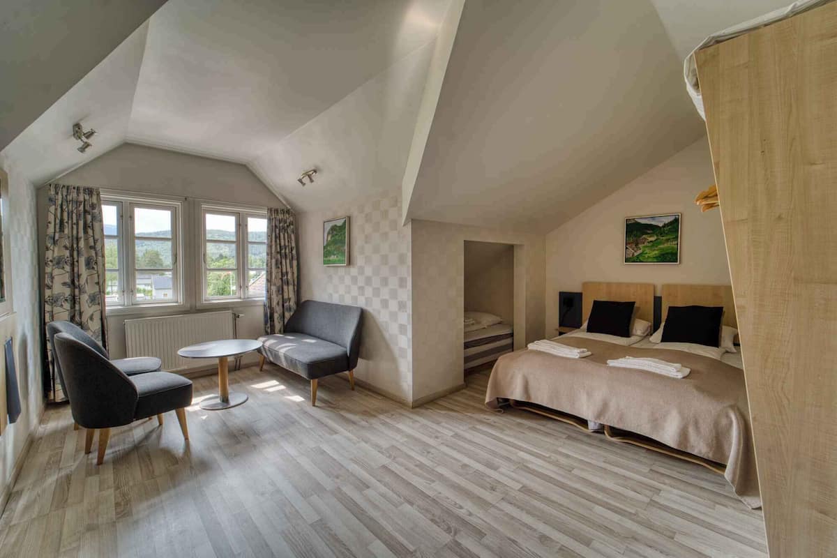 A cozy bedroom with a bed, two bedside tables, a chair, and a small table.