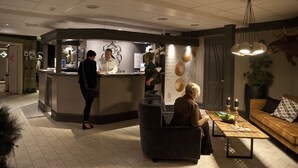 A reception area with a counter, seating, and a coffee table with drinks.