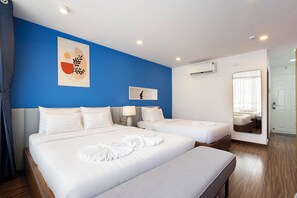 Habitación triple Deluxe | Escritorio, espacio para trabajar con laptop y cortinas blackout 