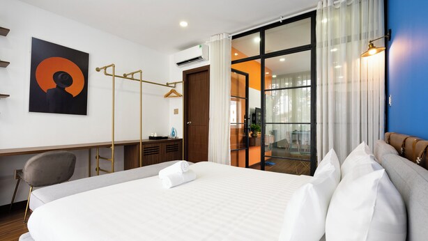 Una habitación de hotel moderna con una cama grande, un escritorio y una silla.