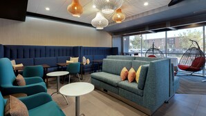 Un espace de détente moderne, doté de sièges, de tables et de fauteuils suspendus.