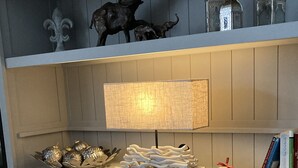 A white cabinet with a lamp, decorative items, and books on top. - 80qm Ruhige, Grüne Innenstadtlage 10 Min. zur Pulsierenden Altstadt (Saarlouis)