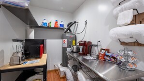 Una kitchenette equipada con cafetera, tostadora, hervidor y dispensador de café.