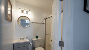 Un baño con inodoro, lavabo y ducha.