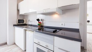 Une cuisine moderne avec des armoires blanches, un comptoir noir et un four à micro-ondes.