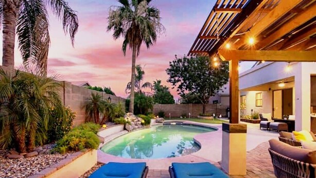 A pool area with lounge chairs, a pergola, and a view of the surrounding landscape. - Relax in Paradise - 4 Bed + 2 Bath w/ Gorgeous Heated Private Pool & Spa! (Peoria)