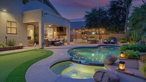 A modern house with a swimming pool, outdoor seating, and a well-lit patio area. - Relax in Paradise - 4 Bed + 2 Bath w/ Gorgeous Heated Private Pool & Spa! (Peoria)