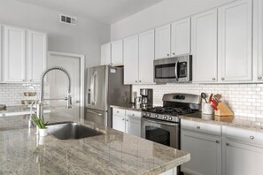 Enjoy cooking in this well-equipped kitchen with a refrigerator, microwave, gas stove, and compact dishwasher.