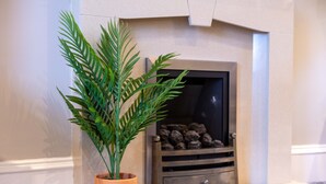 Una chimenea con una planta en maceta a su lado.