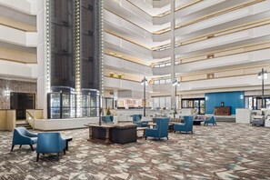 A multi-level hotel lobby with seating areas, a central column, and a reception desk. - Montana Trailhead Inn (Billings)