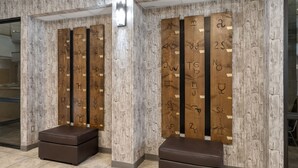A modern restroom with wooden partitions and a bench.